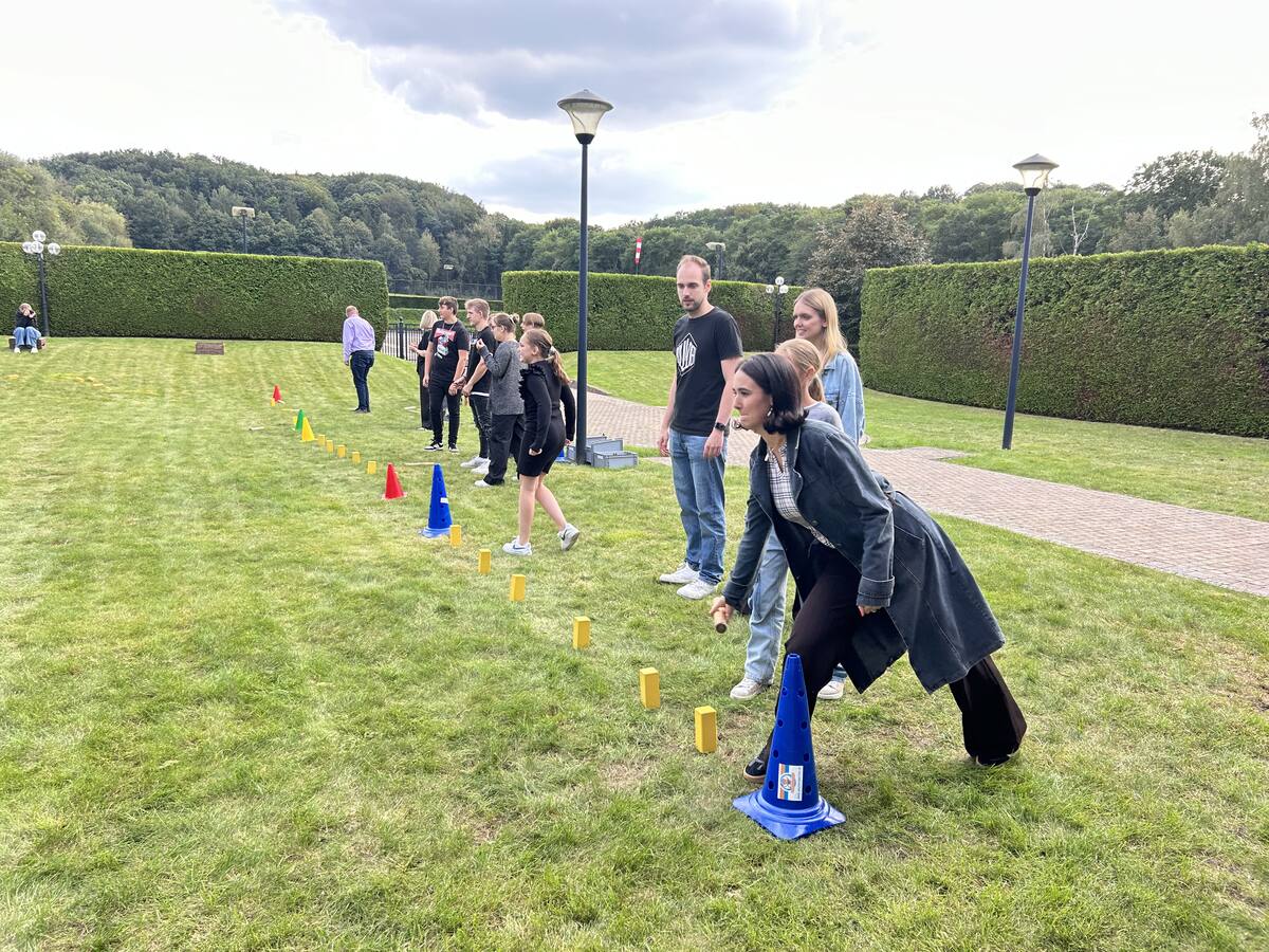 Deelnemer werpt een stok naar de kubbs tijdens een partij Kubb op een zonnige dag