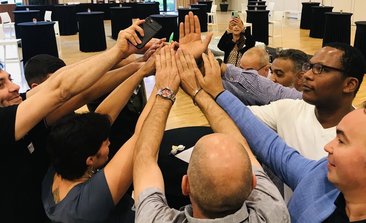 Team geeft elkaar een high five na een geslaagde opdracht tijdens The Ultimate Expedition